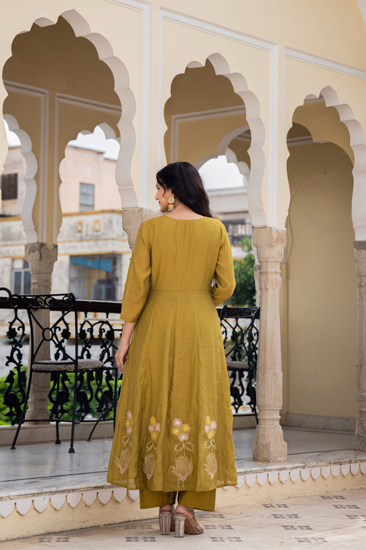 Woman in a green dress standing on a balcony with architectural background