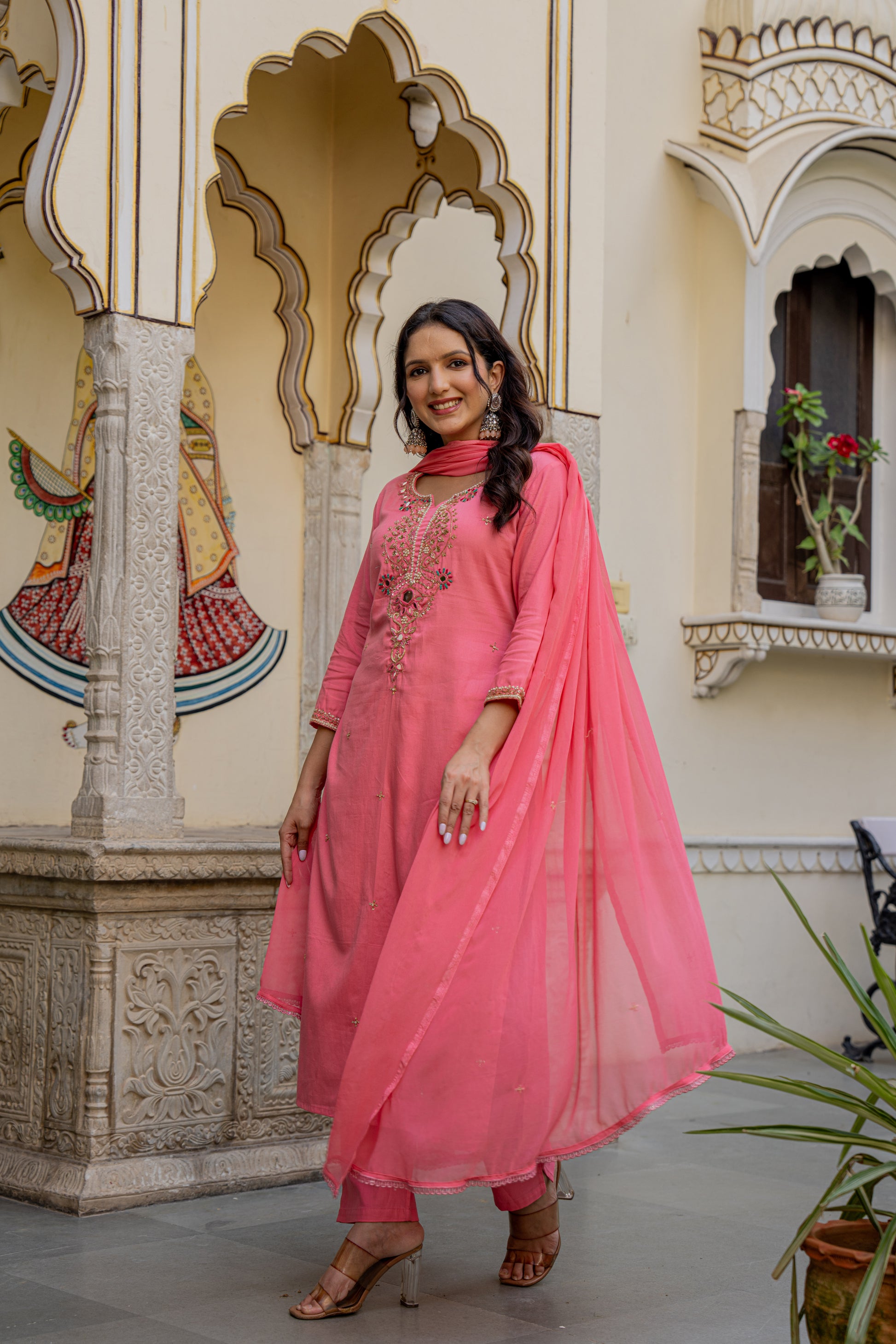 Stylish woman dressed in a pink designer kurta set, captured in an ornate indoor space as a kurta set for wedding.