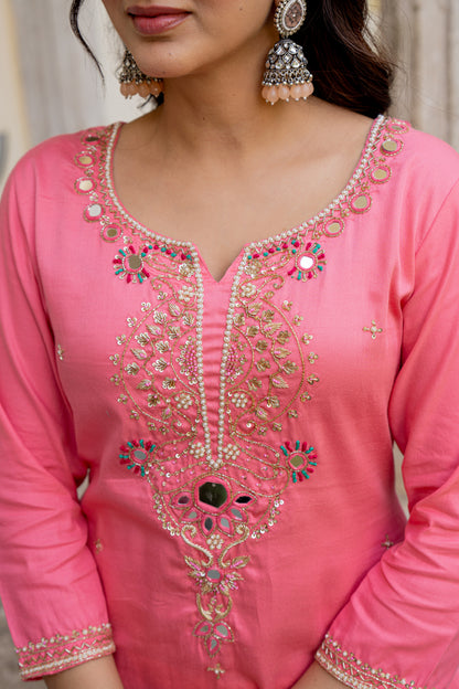 Close-up of a pink traditional outfit with intricate embroidery and embellishments.