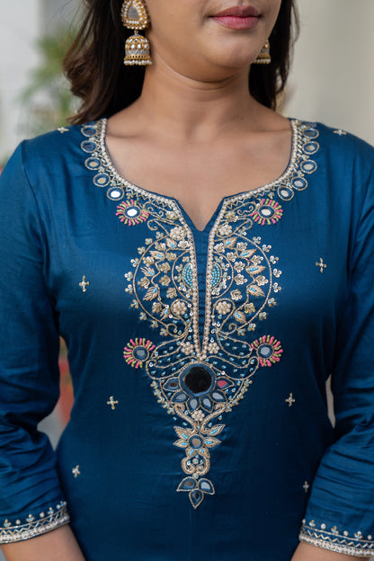 Blue embroidered dress with intricate patterns on a blurred background