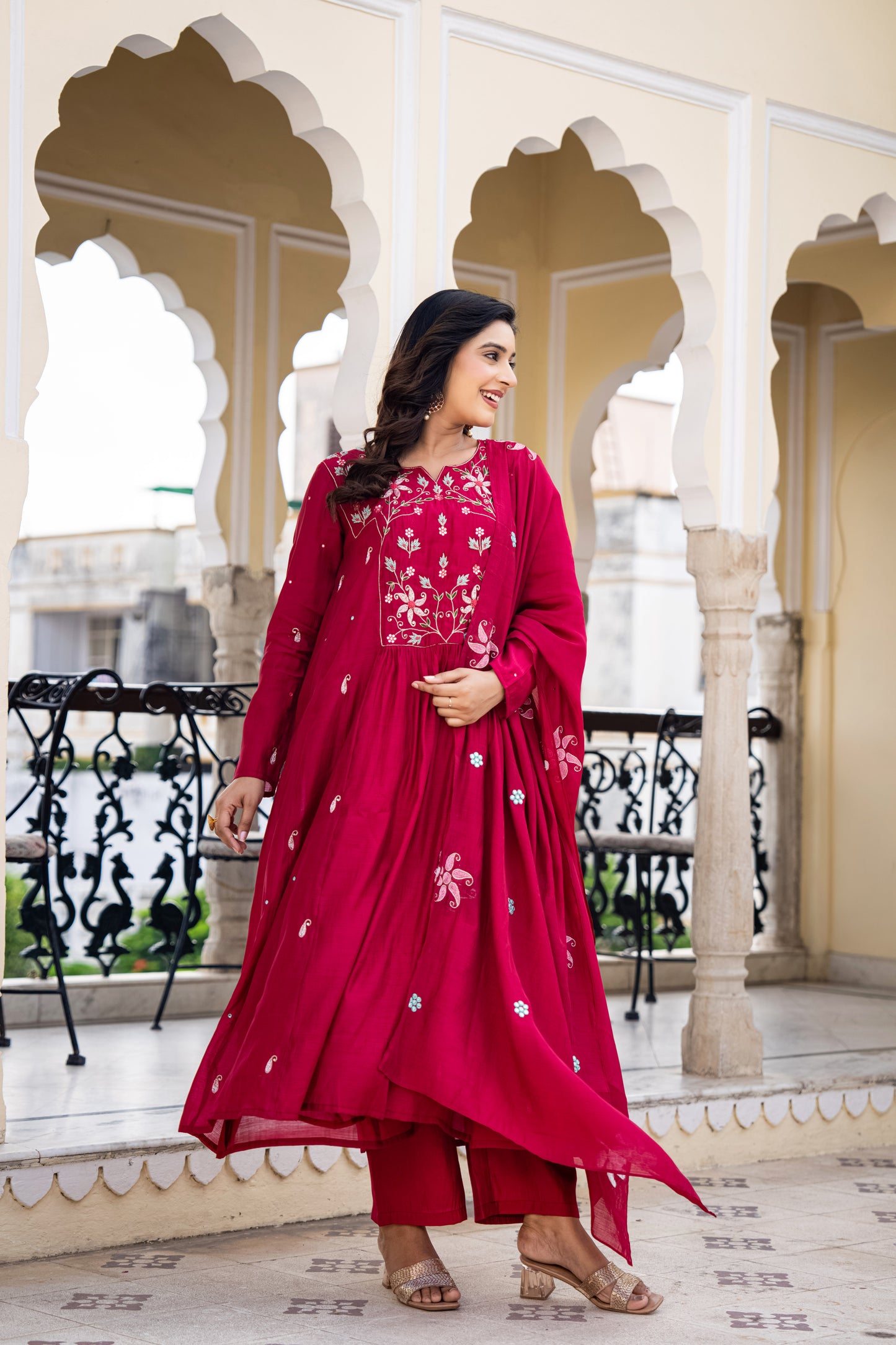Woman in a red traditional outfit standing in an architectural setting