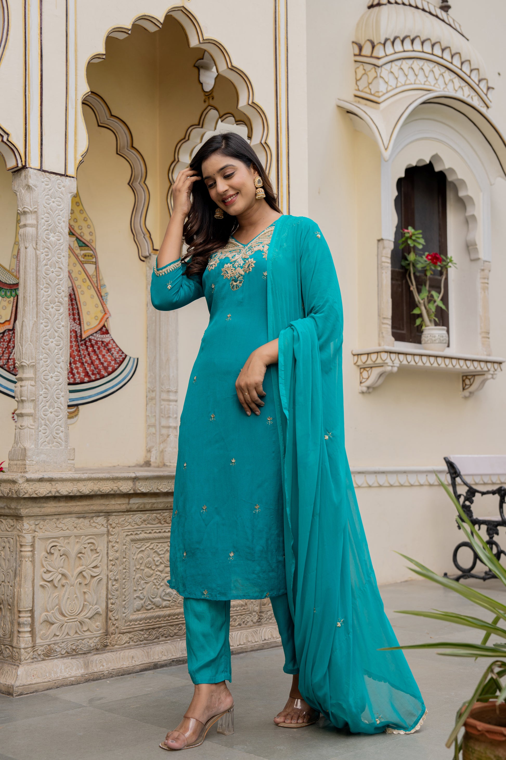 Elegant woman wearing a teal green kurta set for wedding outdoors, showcasing a beautiful designer kurta set.