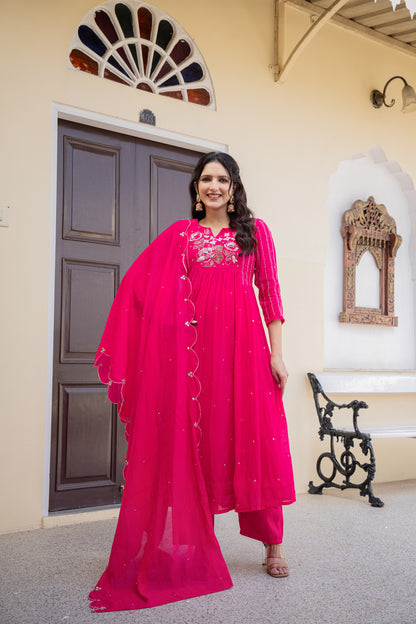 Elegant woman dressed in a pink anarkali kurta set posing in a beautifully adorned room, perfect festive wear for women