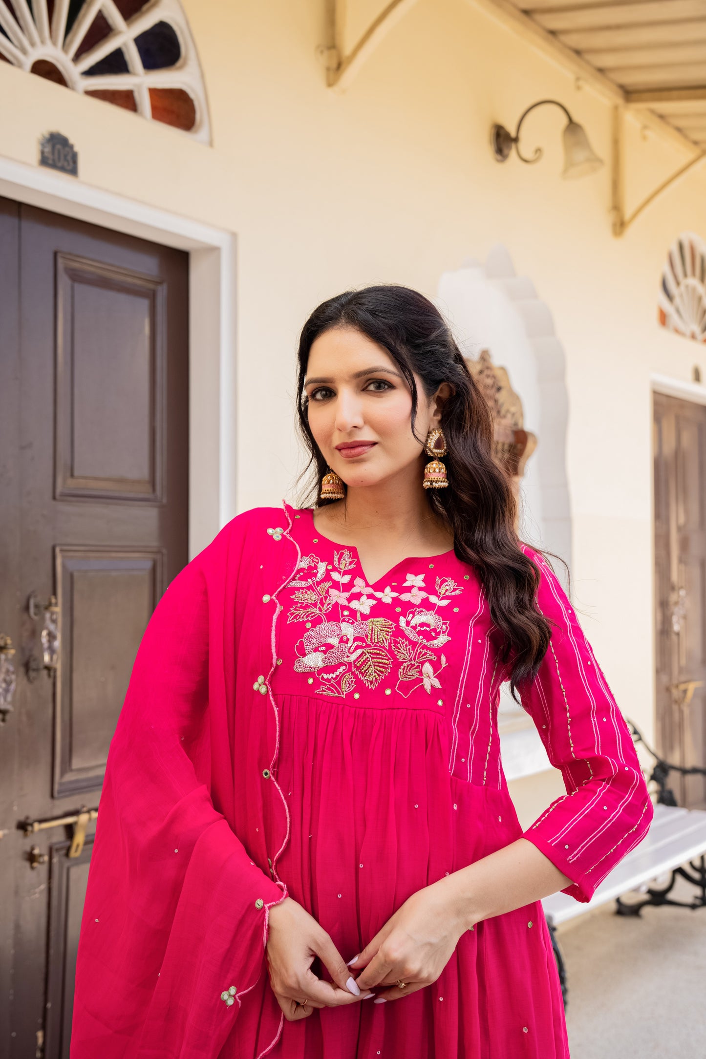 Woman dressed in a rich pink anarkali kurta set with traditional detailing, captured indoors as graceful festive wear for women