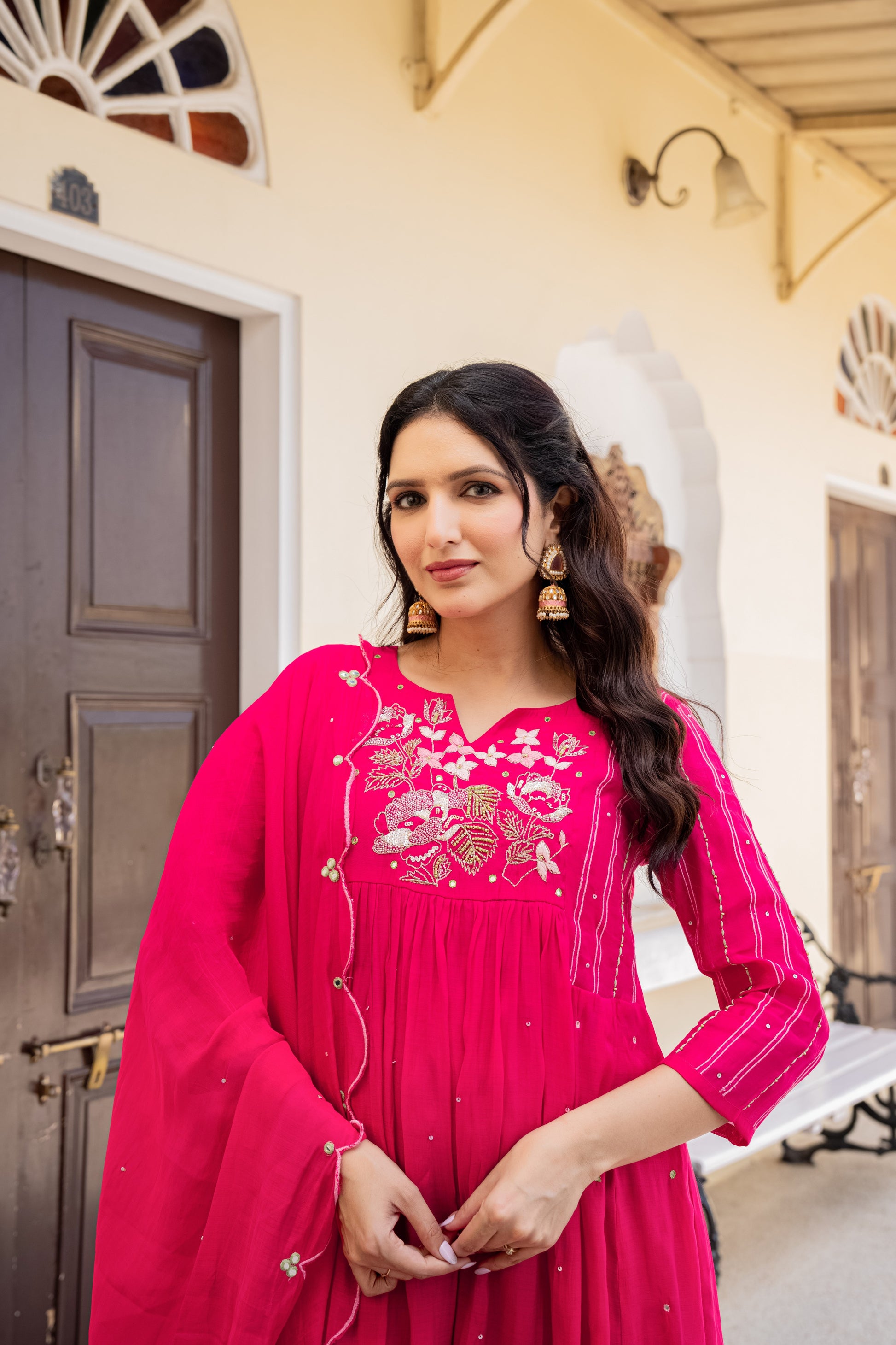 Woman dressed in a rich pink anarkali kurta set with traditional detailing, captured indoors as graceful festive wear for women