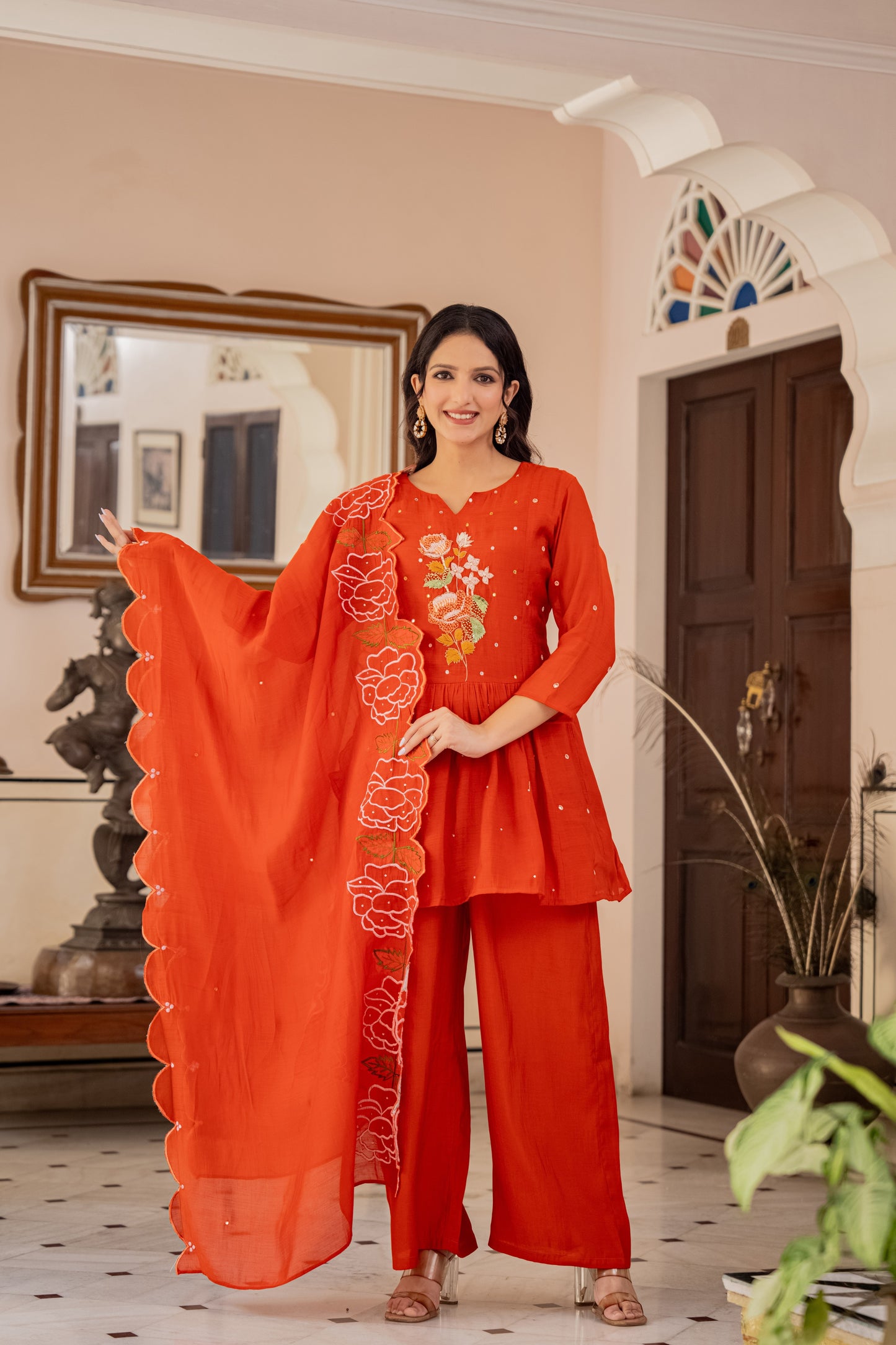 orange floral kurta and palazzo set worn by a woman in an indoor setting with decor, reflecting elegant festive wear for women.
