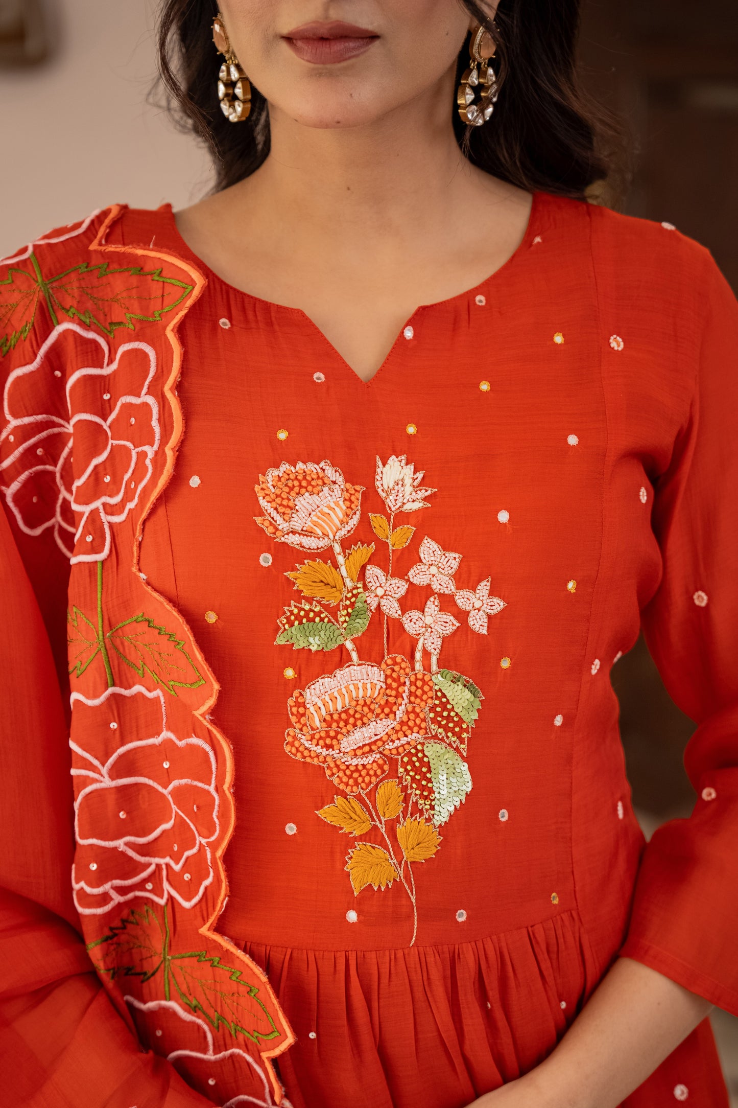 orange embroidered dress with floral patterns worn by a person.