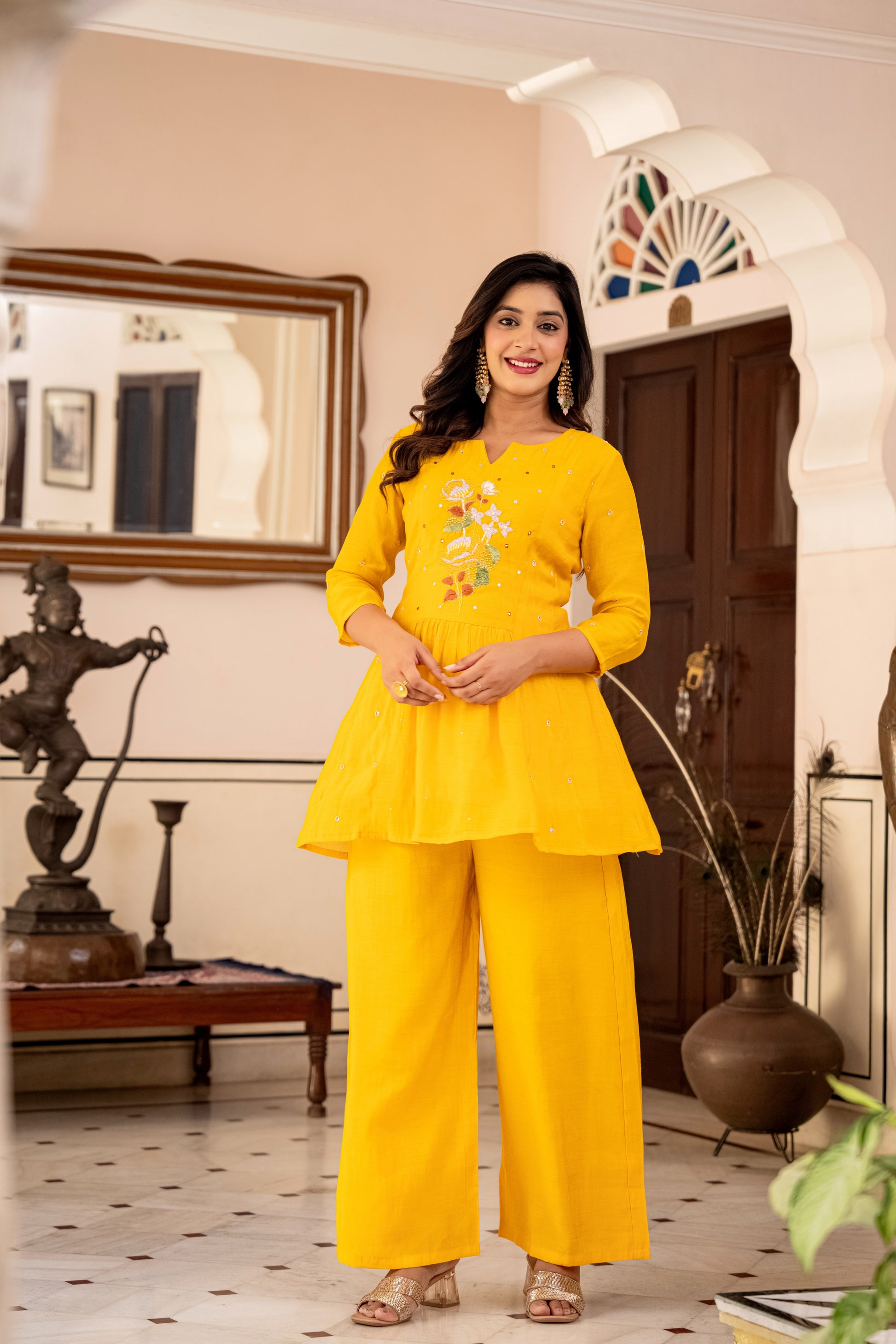 lady wearing a yellow kurta palazzo set for women indoors, styled like a chic kurti with pant set.
