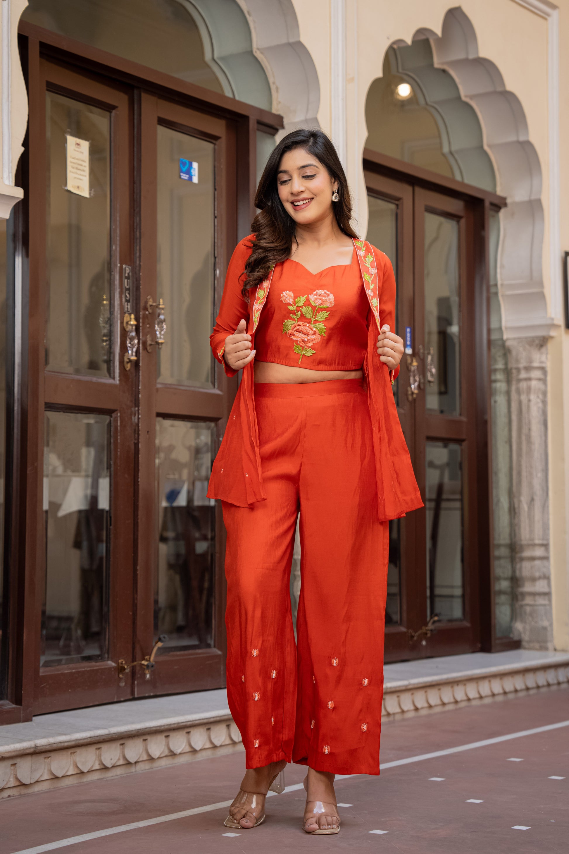 Orange floral kurta palazzo set for women styled beautifully by a woman in an indoor background, representing timeless ethnic sets
